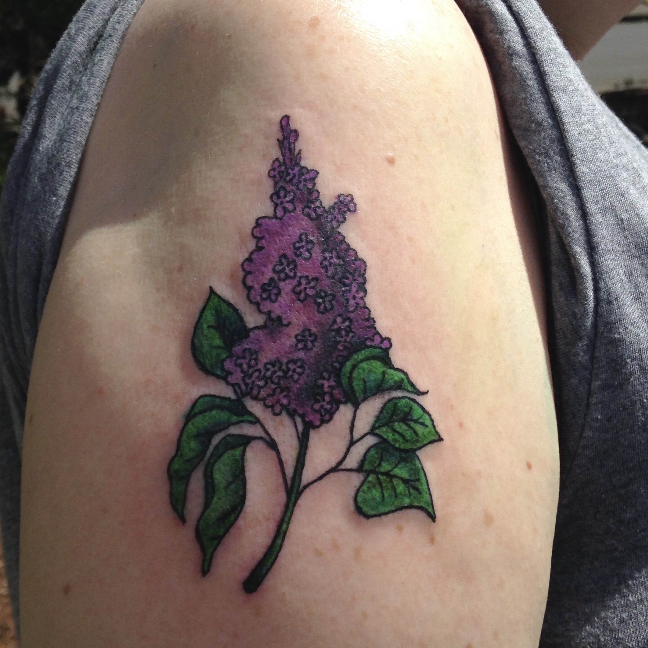 Image of a color lilac tattoo on an upper arm