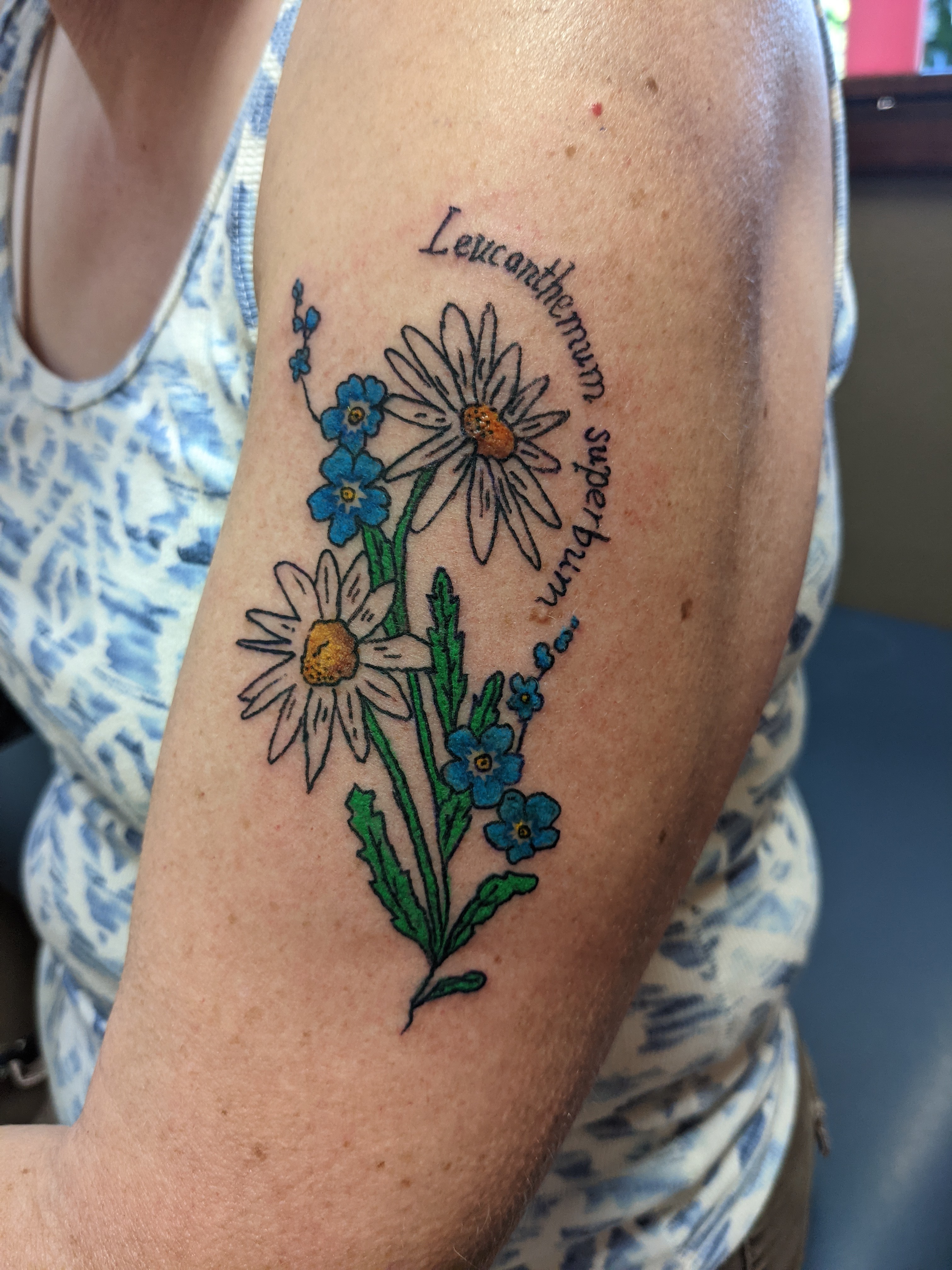 Image of a flower bouquet with daisy’s on an upper arm